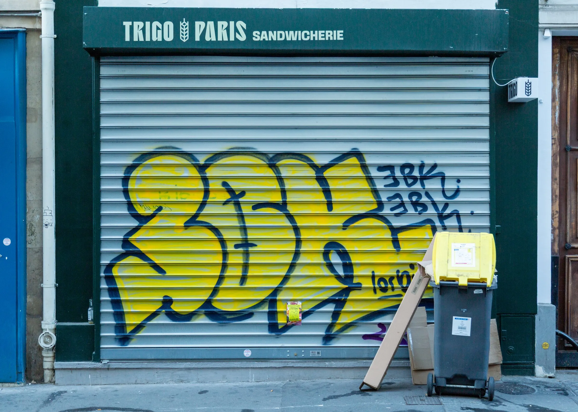 Early-morning walk: a tagged shutter on a sandwich shop