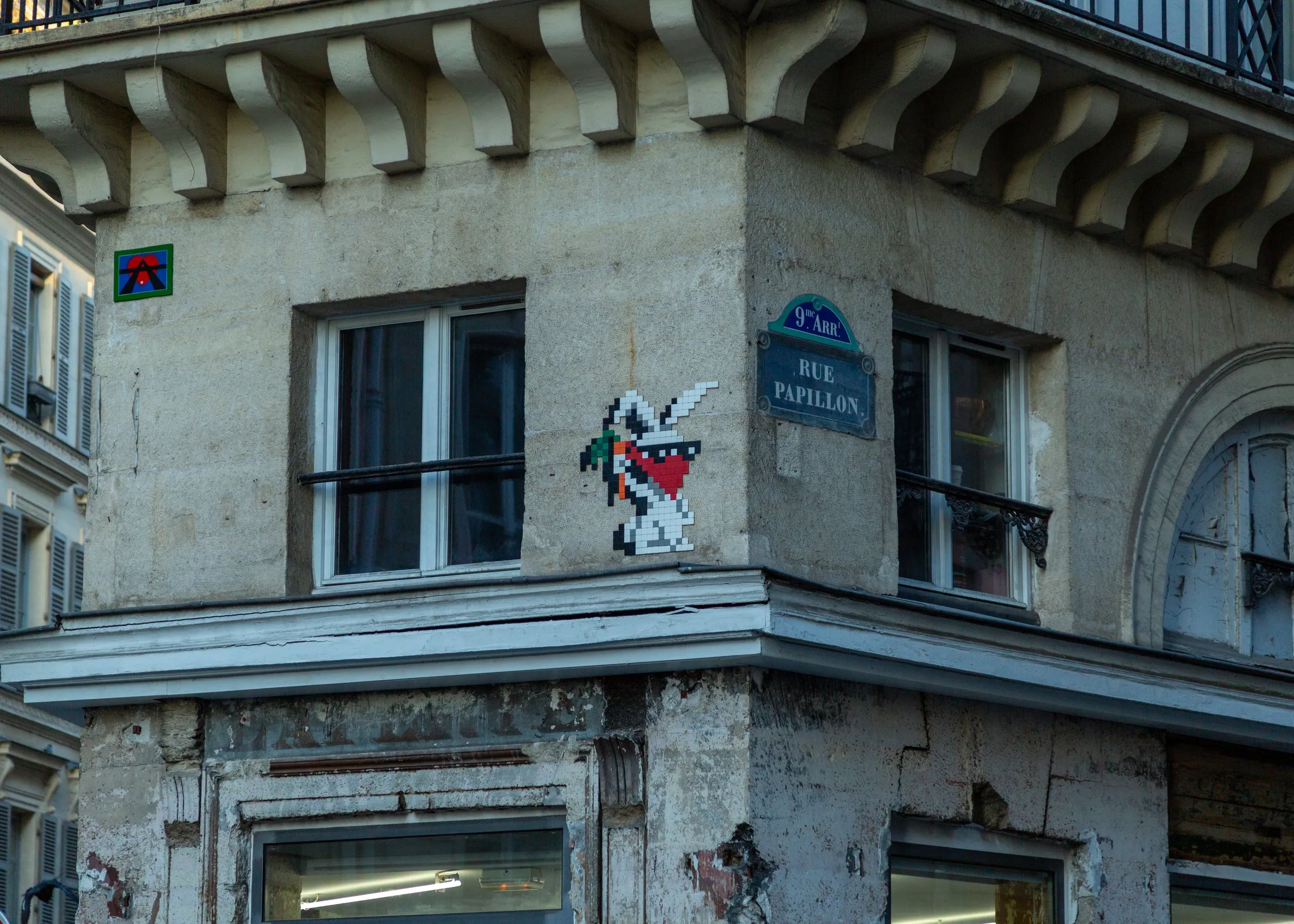 A Space Invader mosaic on the corner of Rue Papillon