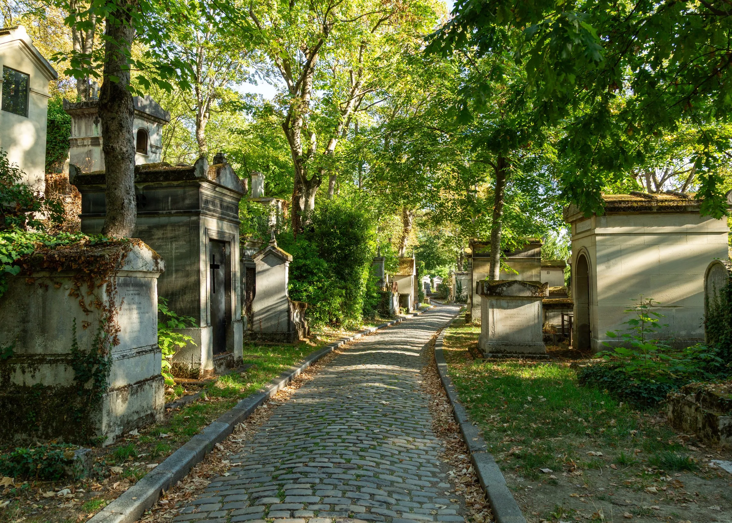 A cobbled lane through Père-Lachaise in late light