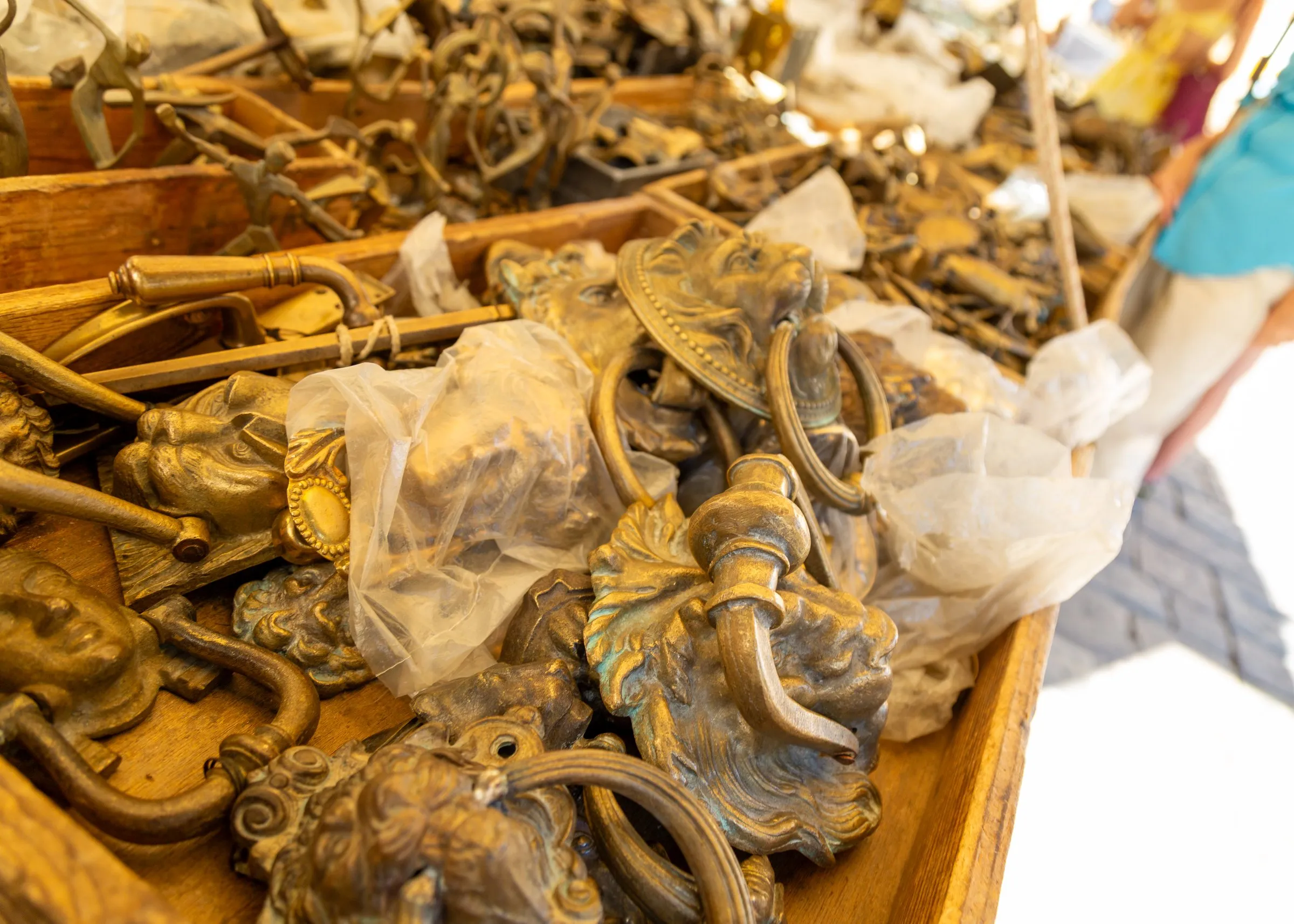 Brass door knockers piled in a box in the Oltrarno
