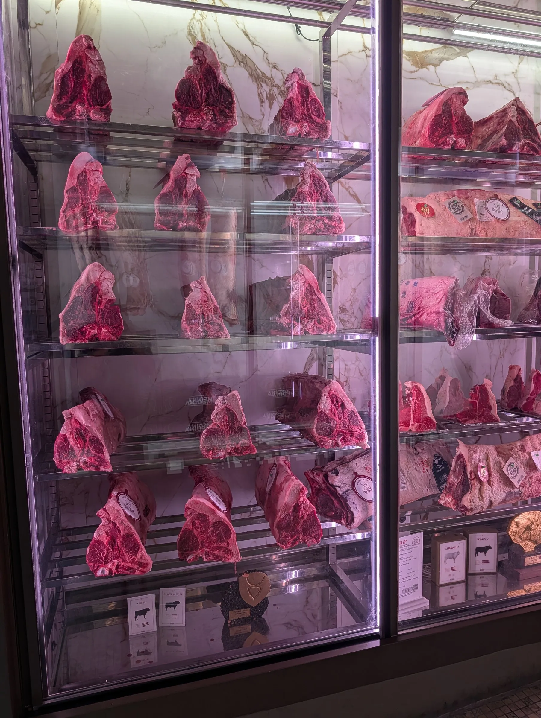 Dry-aged bistecca cuts in a butcher's case