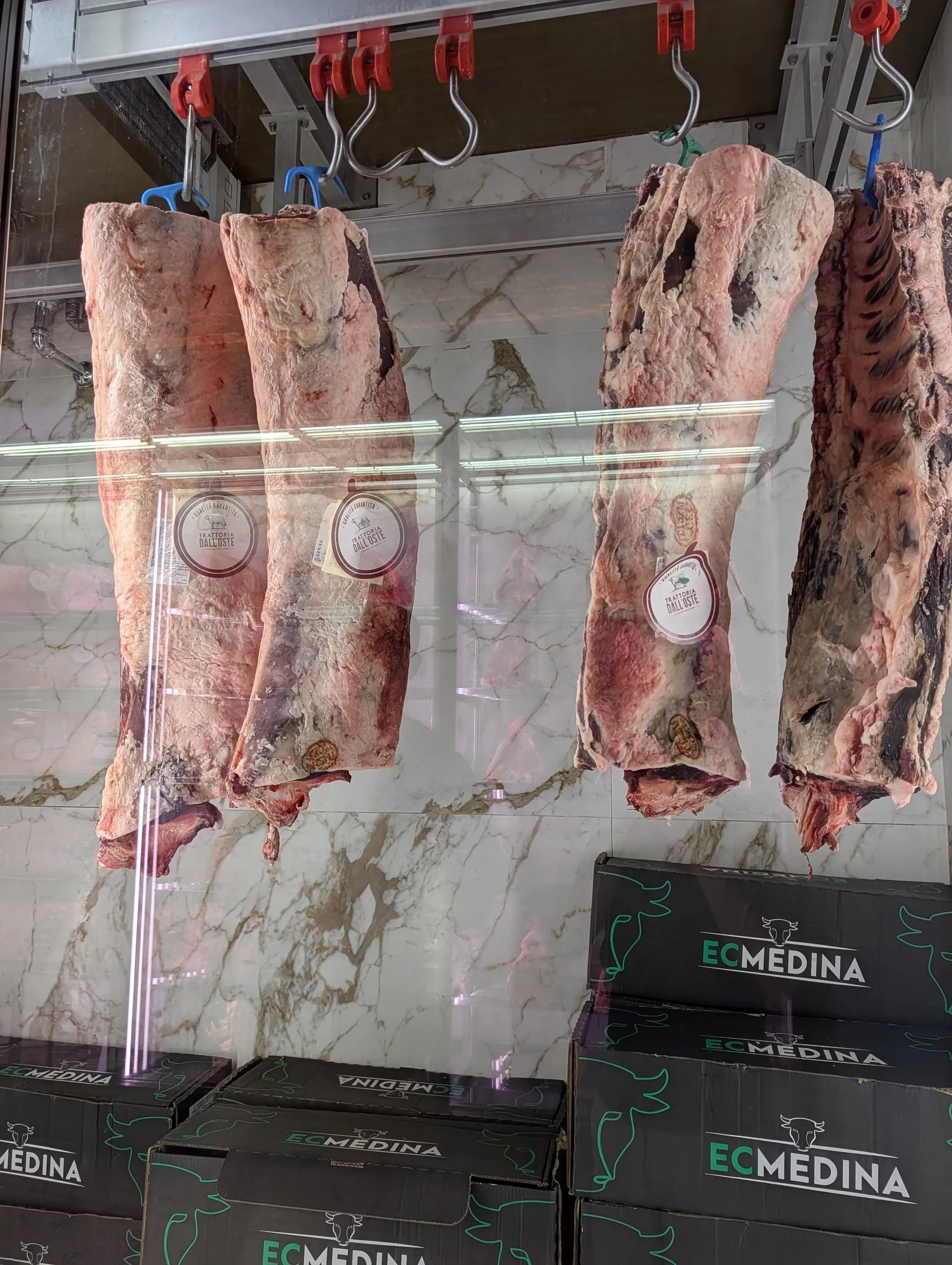 Whole sides of beef hanging in the window