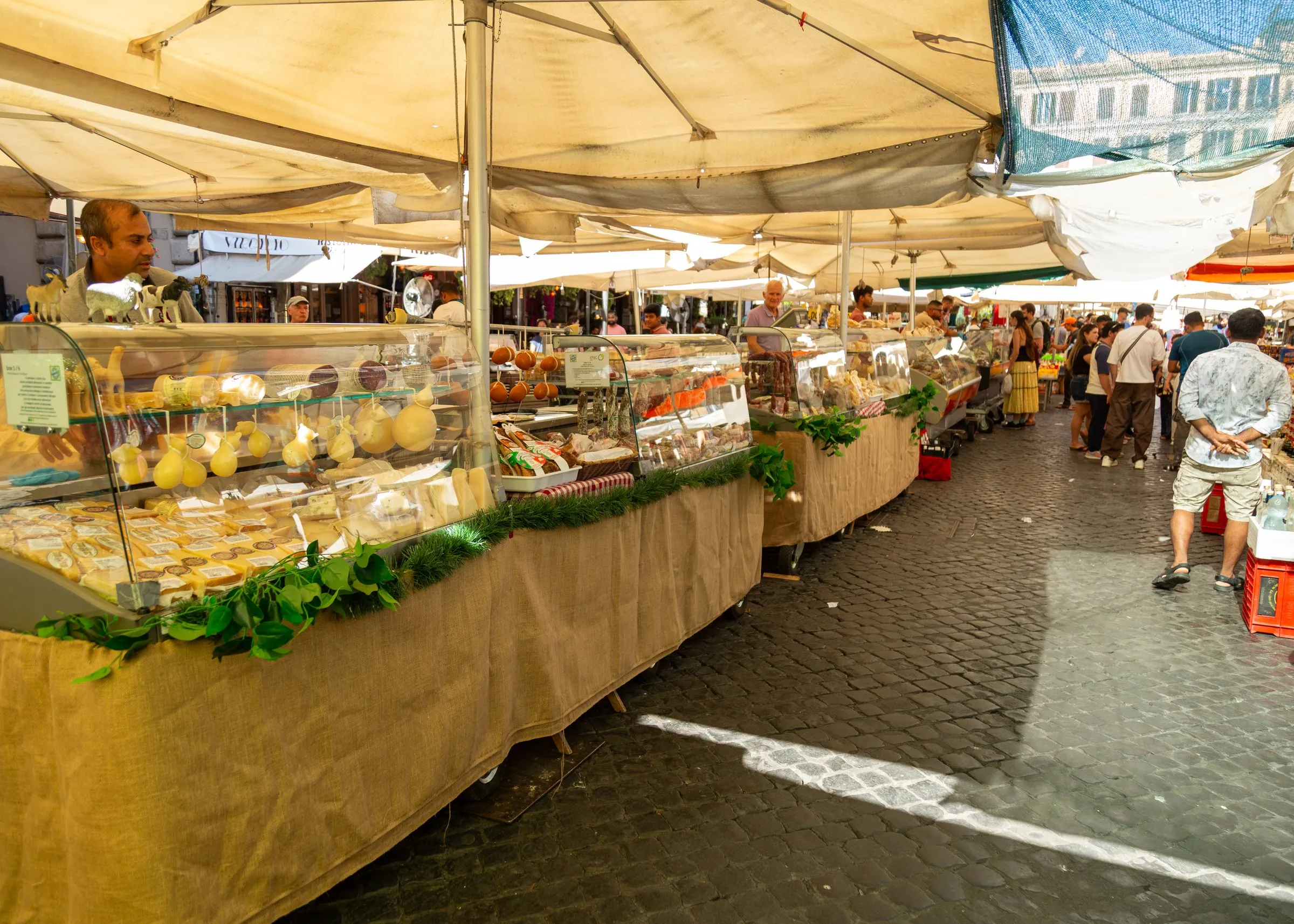 Cheese and produce under the market umbrellas