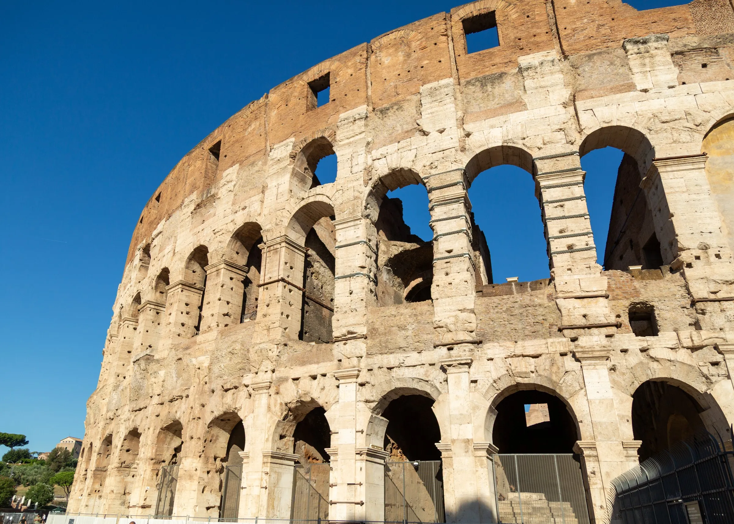The Colosseum's outer wall against a hard blue sky